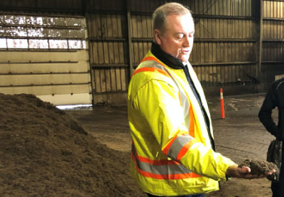 ottowa composting facility man holding some completed compost