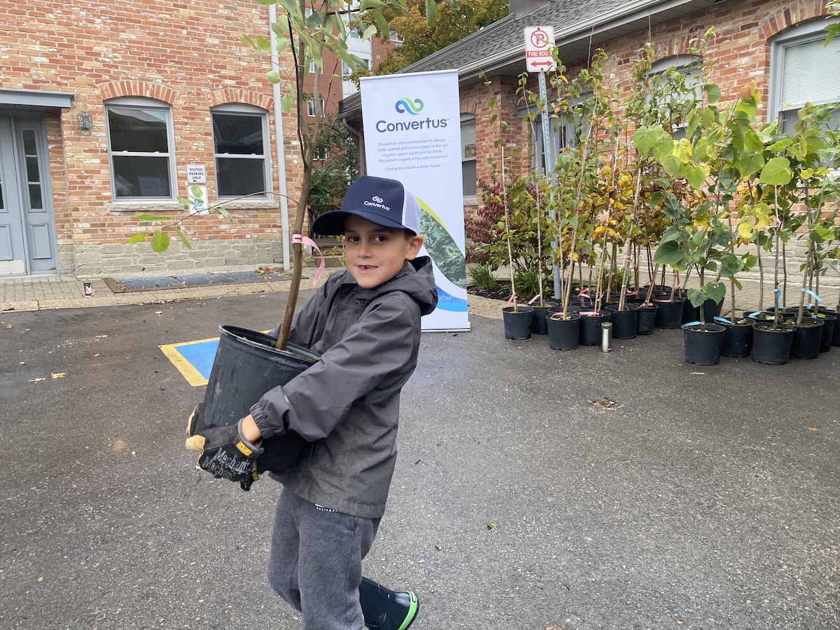 70D3BA2B-2FCF-47D4-955D-3B9E0214F53B young boy carrying a tree from the Neighbourhood Tree Depot.