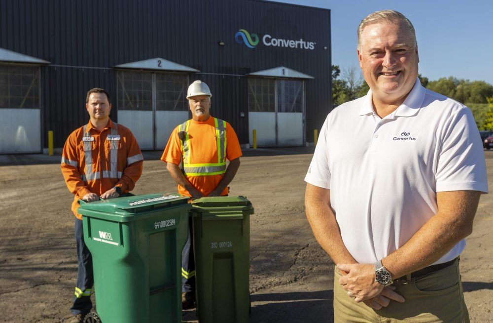 Convertus team standing by green bins.